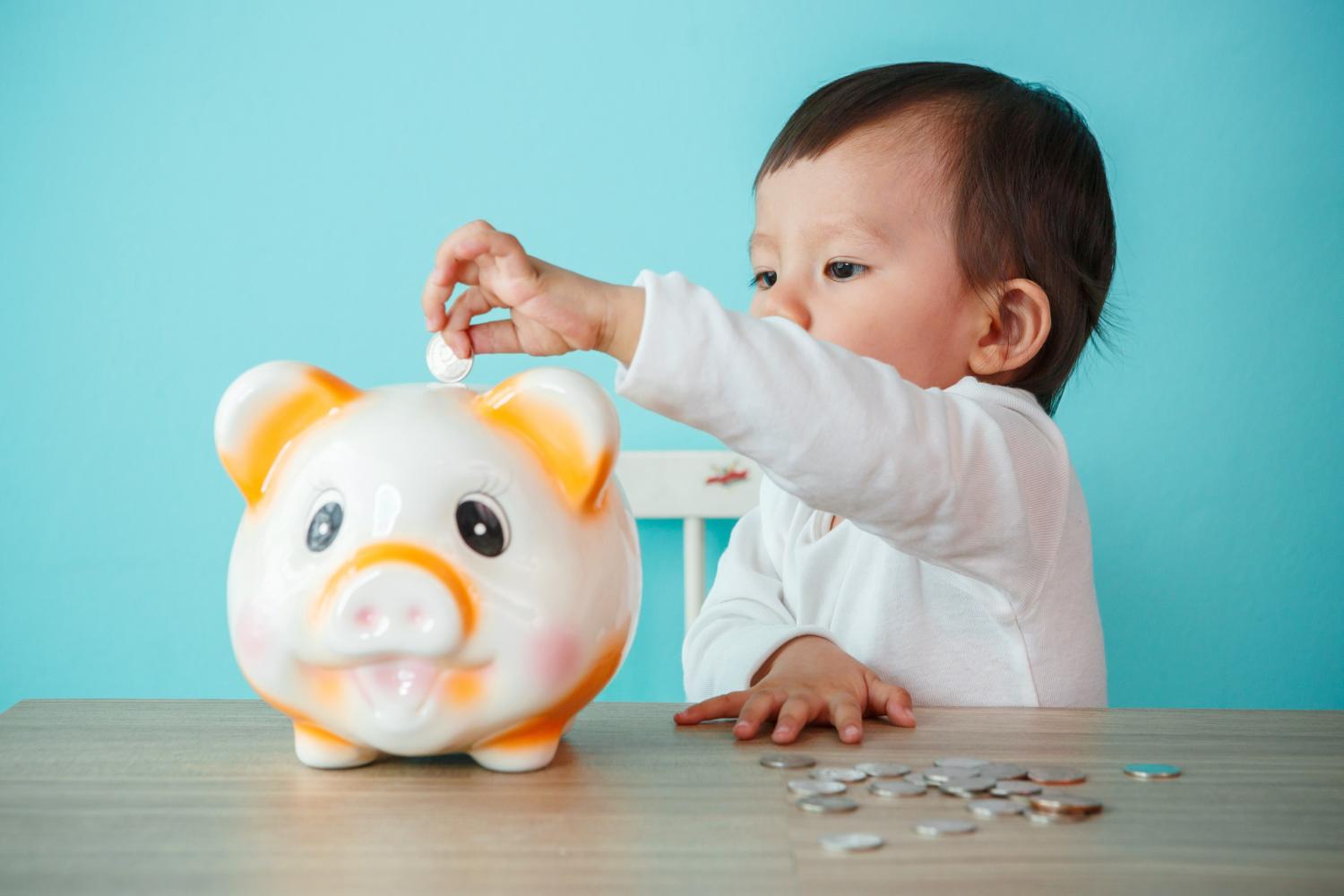 Baby putting money in a piggybank