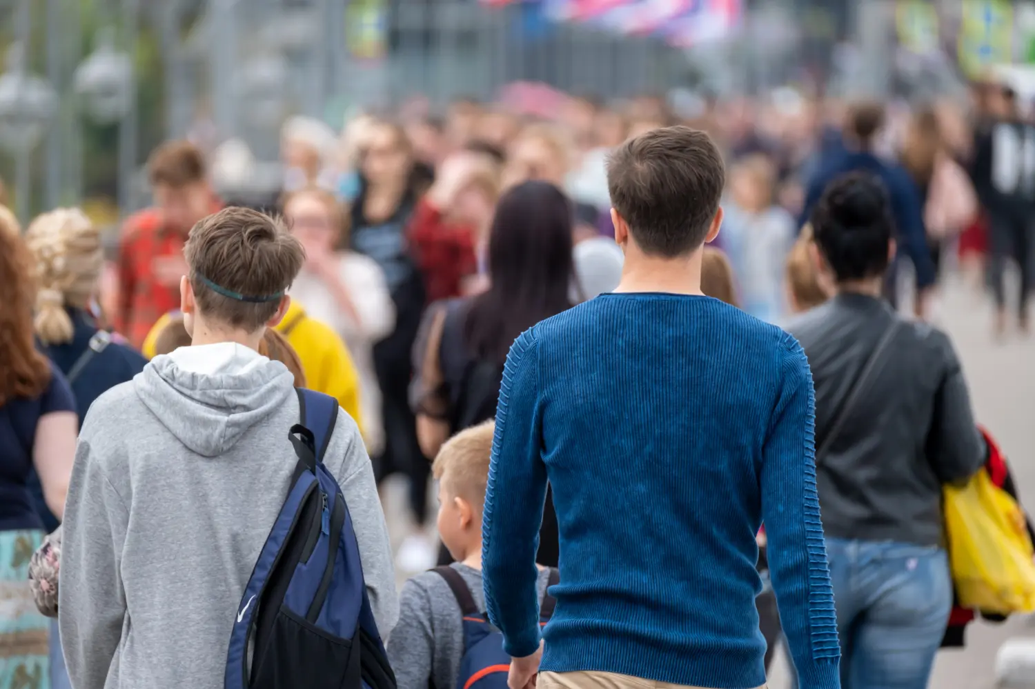 Crowd of people with their back to the camera on the street