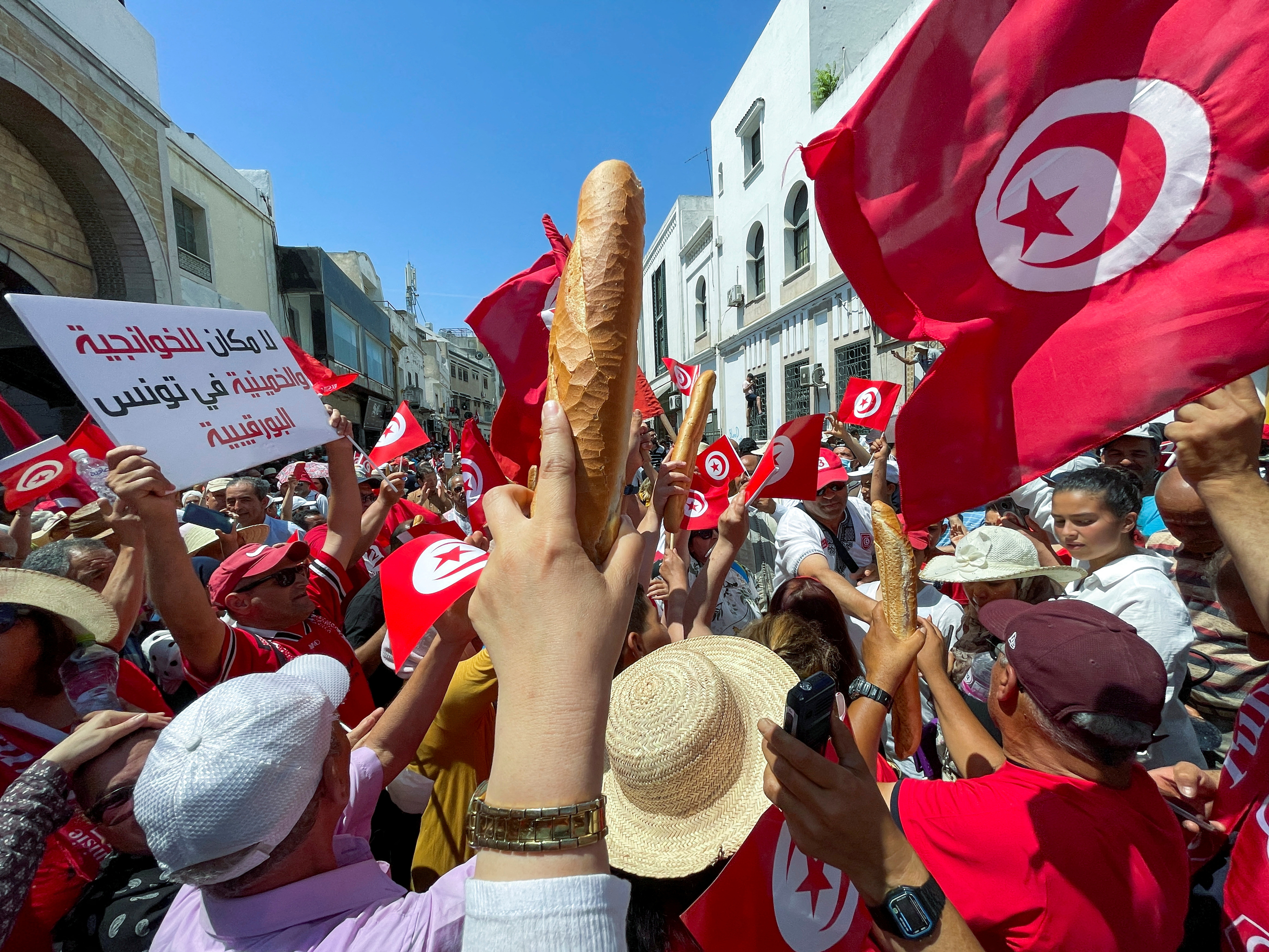 FILE PHOTO: Demonstrators hold loaves of bread as they protest in opposition to a referendum on a new constitution called by President Kais Saied, in Tunis, Tunisia June 18, 2022. REUTERS/Jihed Abidellaoui/File Photo
