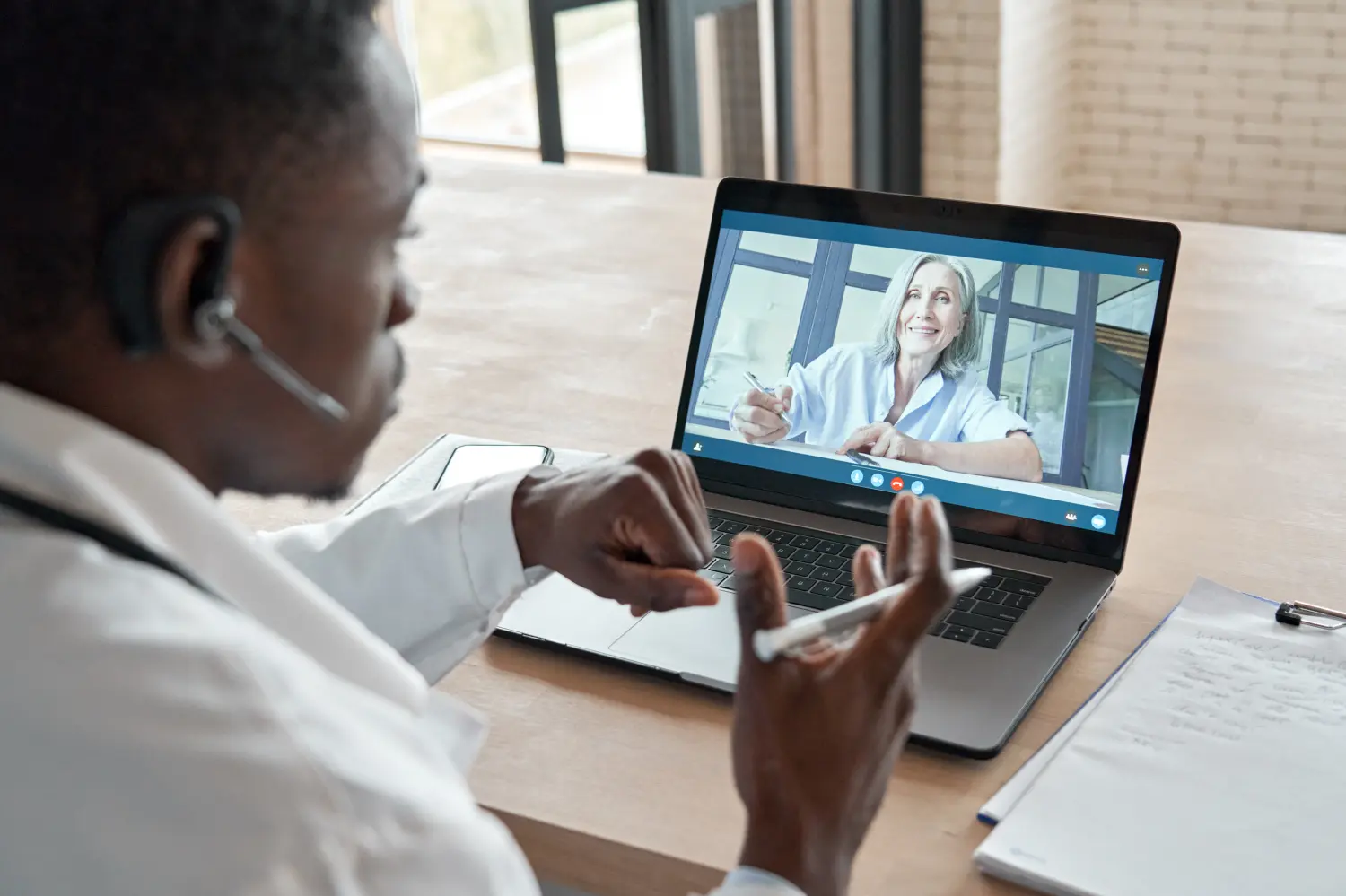 Black doctor and older patient video chatting