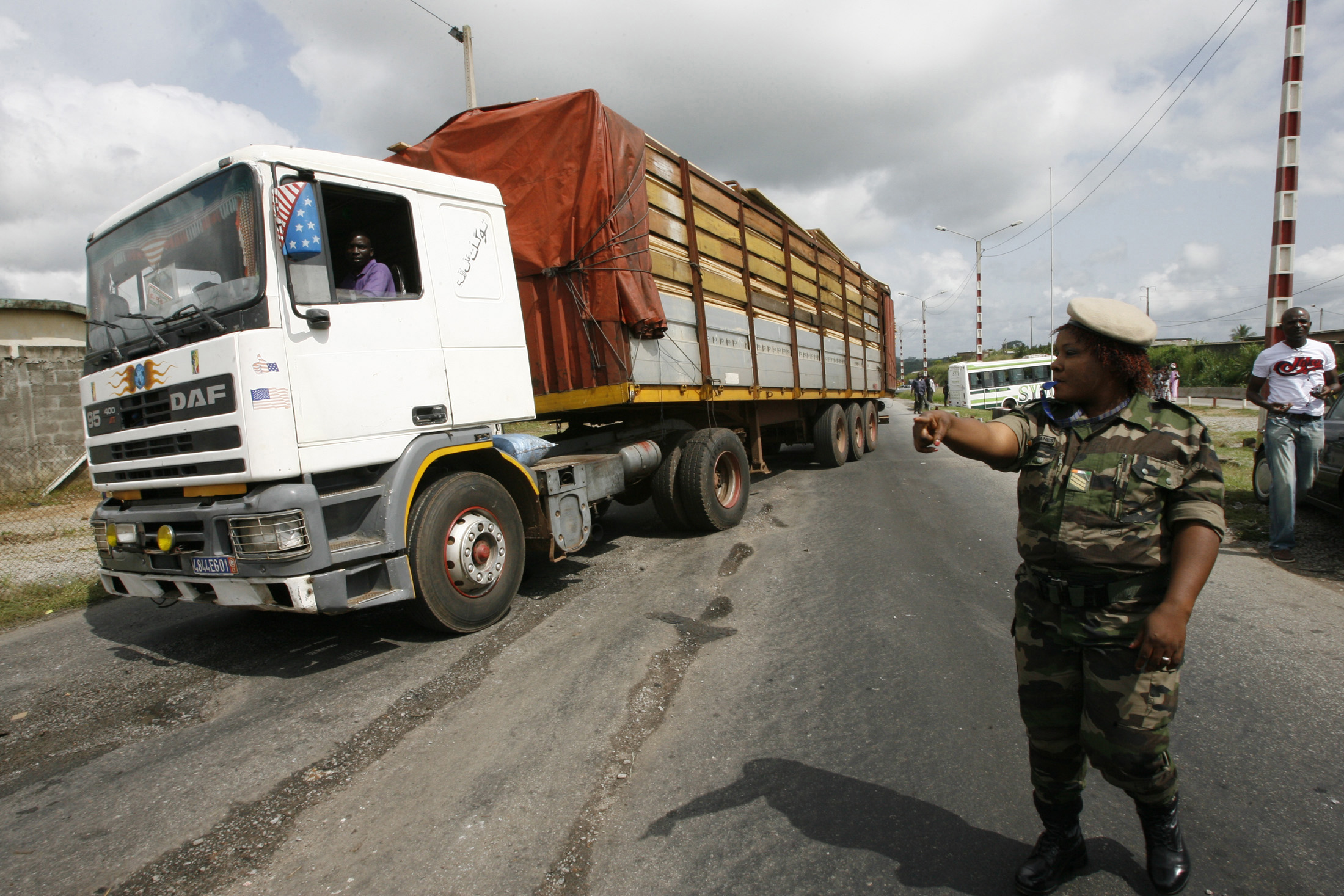 A customs officer redirects a truck at the Yopougon checkpoint in Abidjan June 2, 2008. Ivory Coast authorities recently launched a campaign to crack down on racketeering on the roads and improve traffic.   REUTERS/Luc Gnago (IVORY COAST)