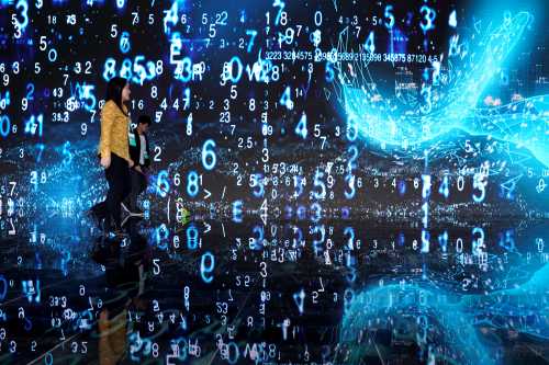 FILE PHOTO: People walks in front of a screen at the World Internet Conference (WIC) in Wuzhen, Zhejiang province, China, October 20, 2019. REUTERS/Aly Song/File Photo