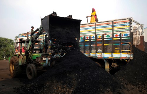 FILE PHOTO: FILE PHOTO: Workers unload coal from a supply truck at a yard on the outskirts of Ahmedabad, India October 12, 2021. REUTERS/Amit Dave/File Photo
