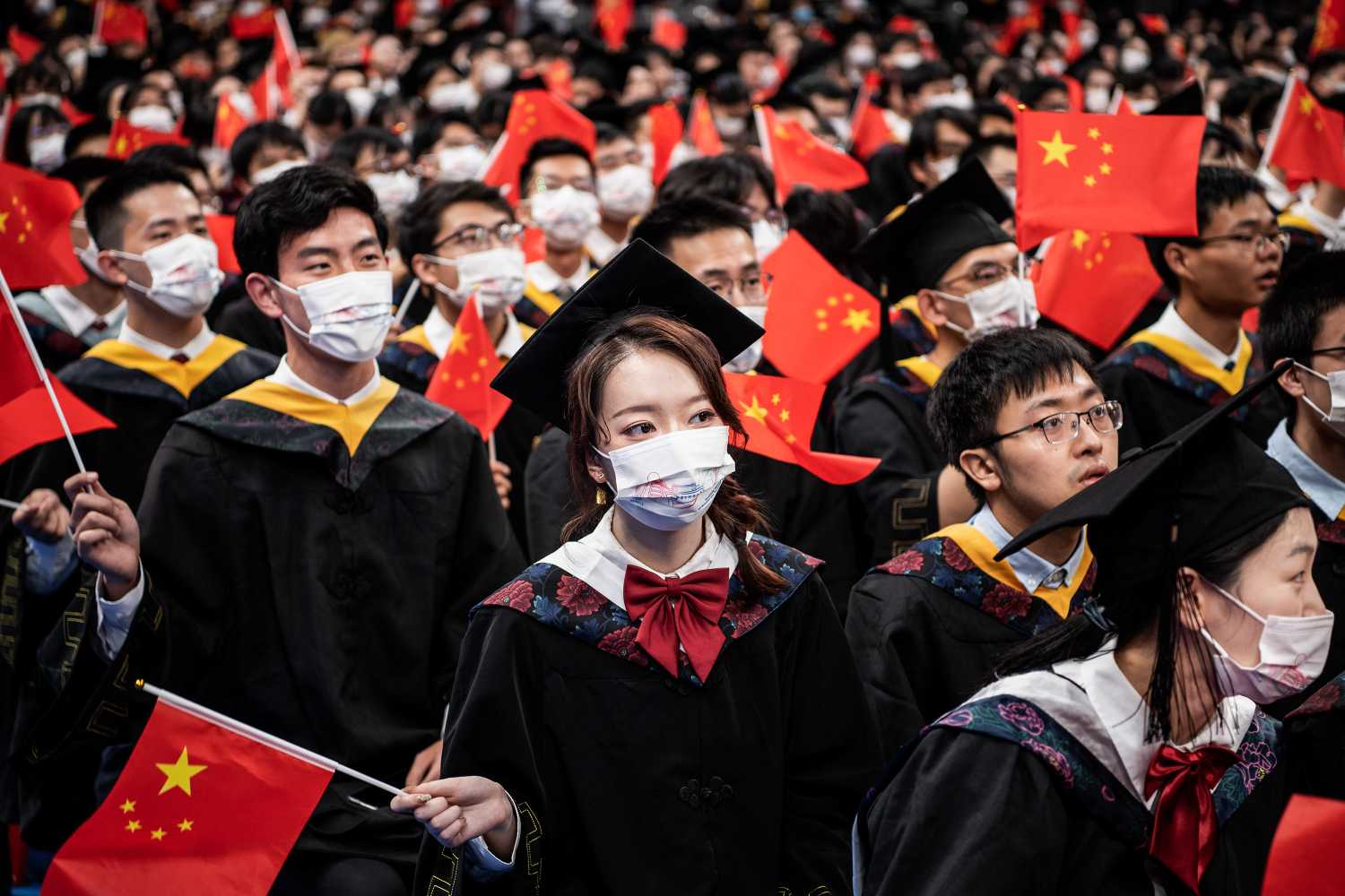 Chinese students from Huazhong University of Science and Technology wave flags during the graduation ceremony in the school's gym.
