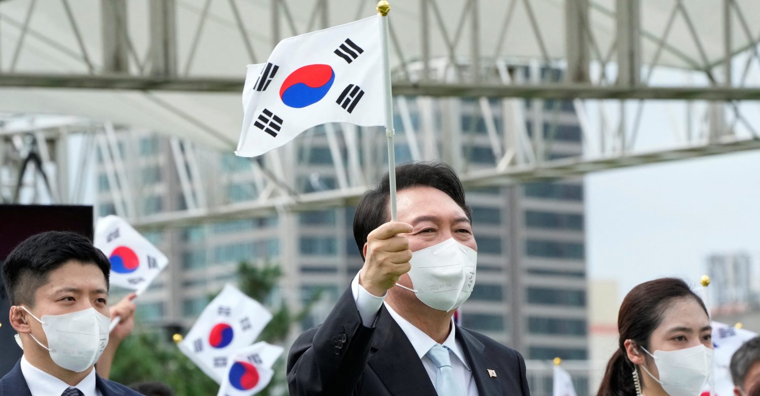 South Korean President Yoon Suk-yeol waves a national flag during a ceremony to celebrate Korean Liberation Day from Japanese colonial rule in 1945, at the presidential office square in Seoul, South Korea, August 15, 2022. Ahn Young-joon/Pool via REUTERS