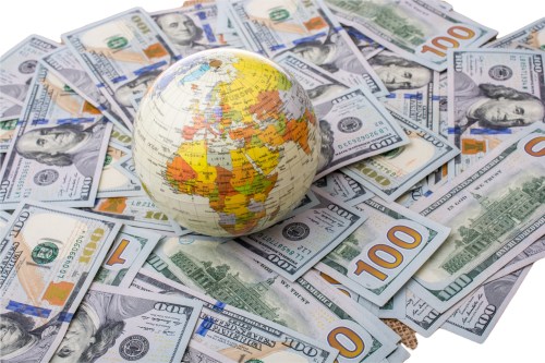 Globe on pile of one hundred dollar bills