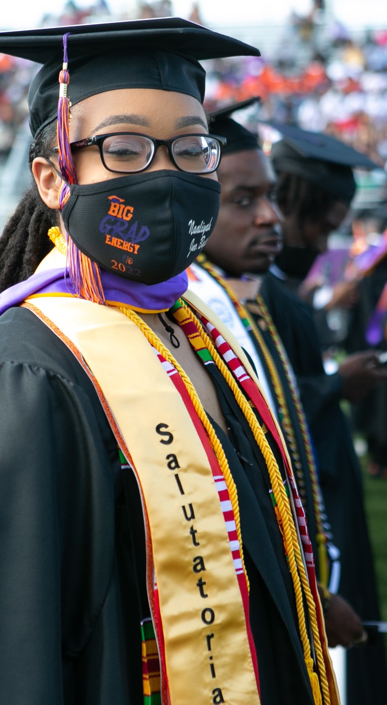 Edward Waters University graduate looking at cameraat graduation