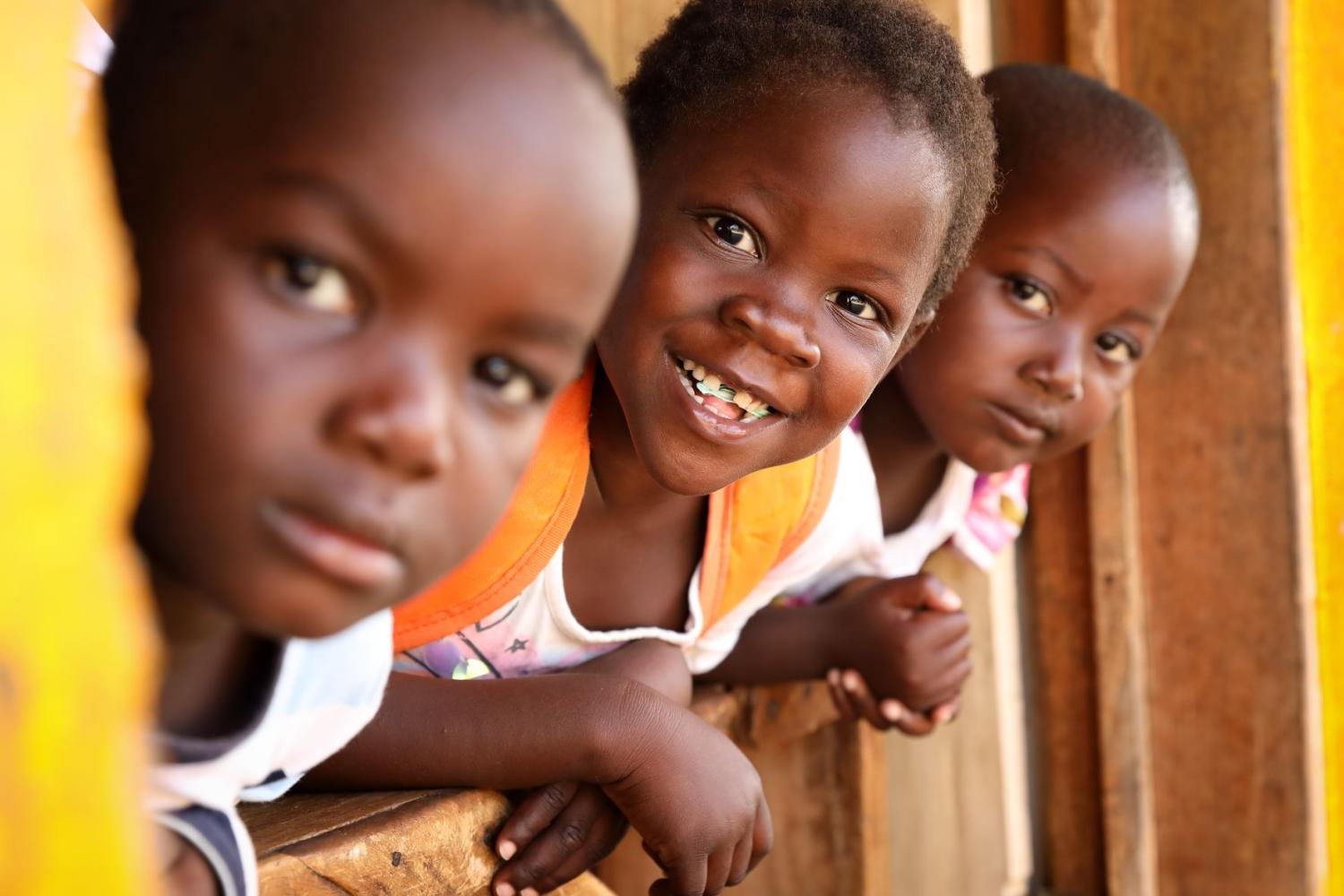 Children lean out of a school classroom in sub-Saharan Africa.