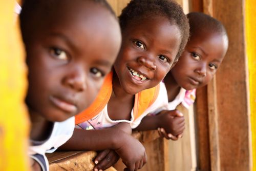 Children lean out of a school classroom in sub-Saharan Africa.