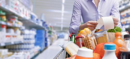 Woman looking at receipt in a grocery store.