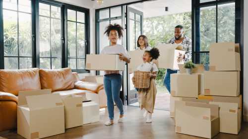 Happy Black family moving into new house filled with boxes