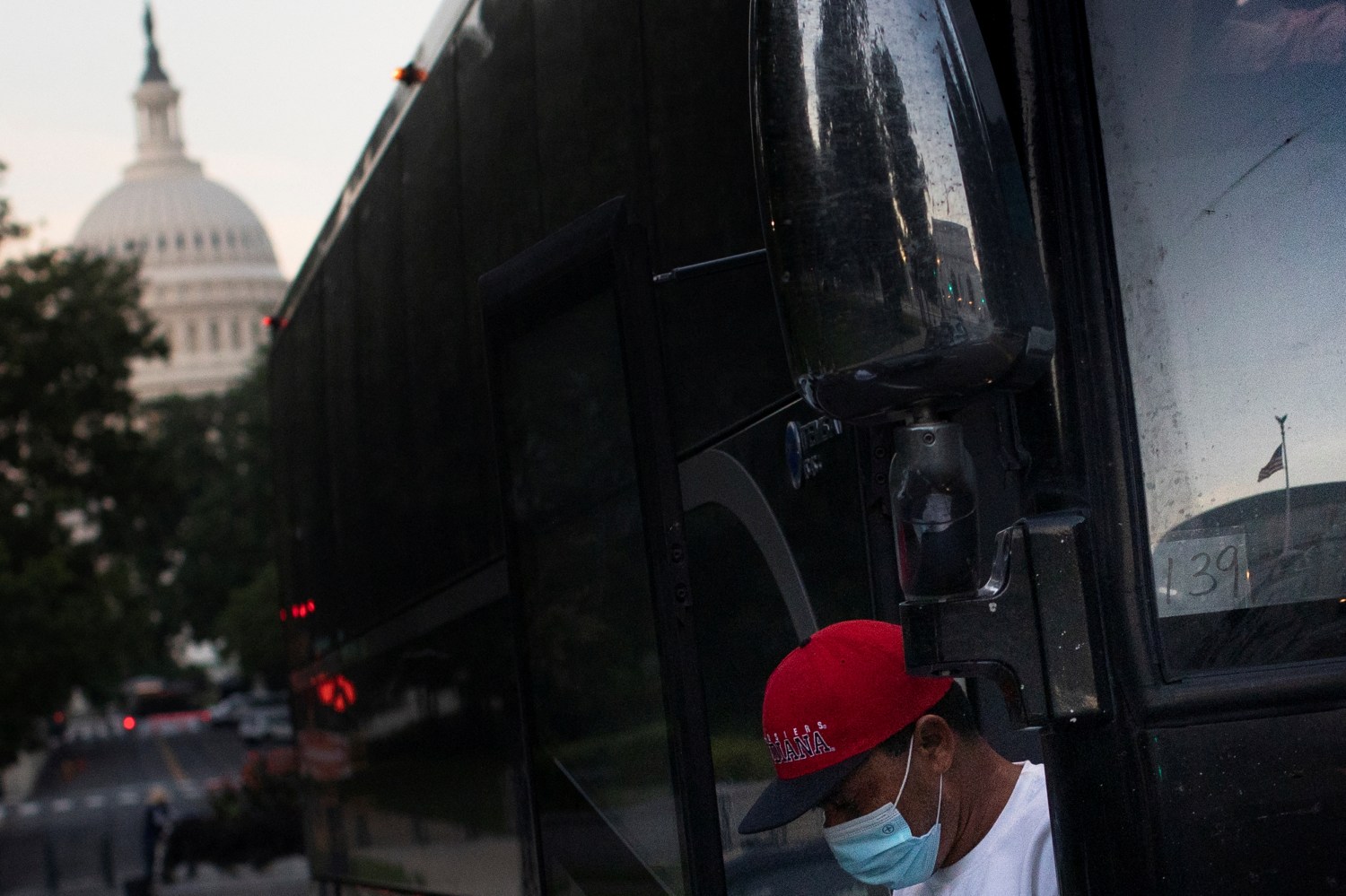 A migrant exits a bus during early morning hours following a travel from Texas, outside the U.S. Capitol in Washington, U.S., July 30, 2022. REUTERS/Tom Brenner