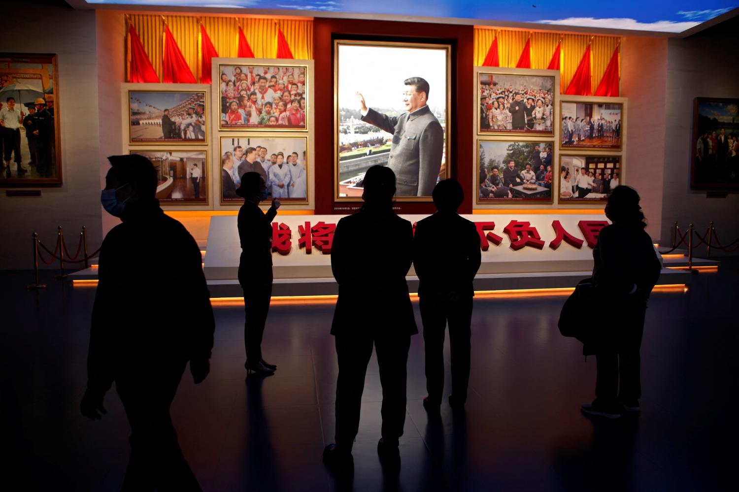 A guide talks to visitors in front of images of Chinese President Xi Jinping, at the Museum of the Communist Party of China in Beijing, China October 13, 2022. REUTERS/Florence Lo
