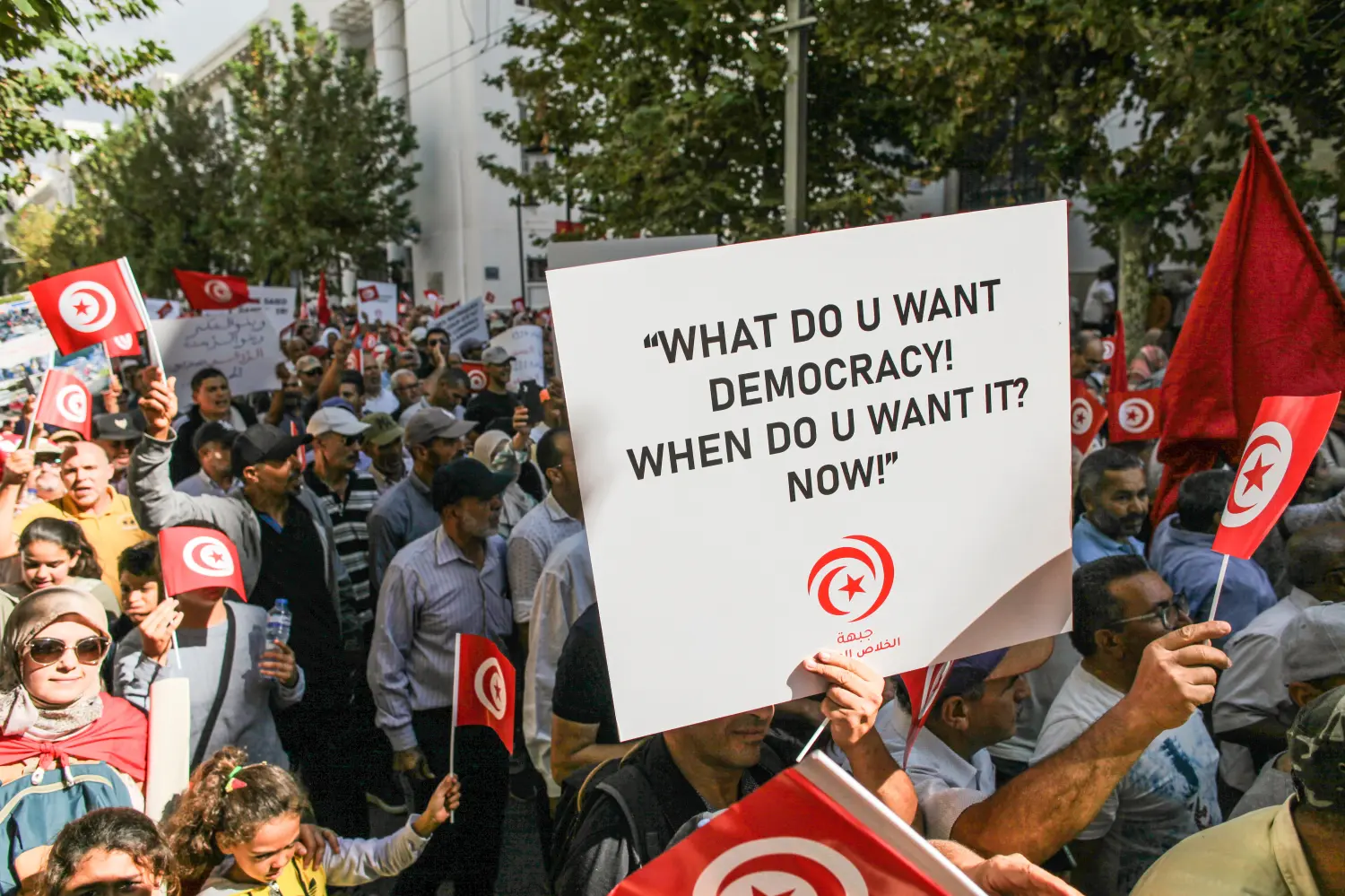 Tunisia, Tunis, 2022-10-15. A demonstrator holds up a sign that reads, what do you want democracy! When do you want it now!, as others chant slogans while holding up Tunisian flags, during a demonstration held by the National Salvation Front (a Tunisian political group opposing the President Kais Saied), on the occasion of the 59th anniversary of the evacuation Day, to protest against what the demonstrators called a coup by the President Kais Saied, as well as against the upcoming early parliamentary elections. They also protested against the measures Said has taken since 25 July 2021and demanded his departure. The crowd also protested against what they consider a return to dictatorship and an attack on Democracy. Photograph by Chedly BEN IBRAHIM / Hans Lucas.Tunisie, Tunis, 2022-10-15. Un manifestant brandit une pancarte sur laquelle on peut lire : Que voulez-vous de la democratie Quand la voulez-vous maintenant ! , tandis que d autres scandent des slogans tout en brandissant des drapeaux tunisiens, lors d’une manifestation organisee par le Front De Salut National (une coalition d’entites politiques Tunisiennes s’opposant au president Kais Saied), a l’occasion du 59e anniversaire de la Fete de l’evacuation, pour protester contre ce que les manifestan mmts appellent coup d’etat du president Kais Saied, ainsi que contre les prochaines elections legislatives anticipees. ils ont aussi proteste contre les mesures que le president Saied a prises depuis le 25 juillet 2021 et ont reclame son depart ainsi que la chute du regime. La foule a aussi proteste contre ce qu’elle considere comme un retour a la dictature et une atteinte a la democratie. Photographie par Chedly BEN IBRAHIM / Hans Lucas.