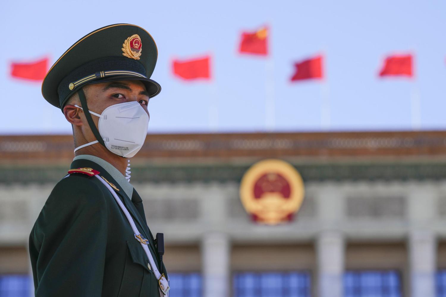 A security official wearing a face mask amid COVID-19 concerns stands guard on Oct. 22, 2022, near Beijing's Great Hall of the People (back), where the 20th National Congress of the Chinese Communist Party concluded the same day. (Kyodo)==KyodoNO USE JAPAN