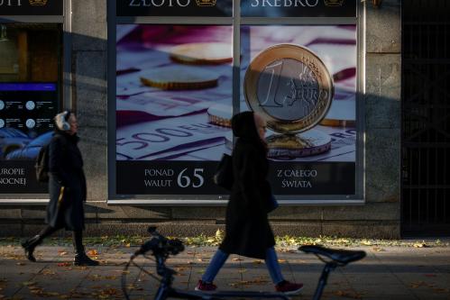 People are seen walking past a shop for buying and selling god and silver with a Euro coing printed on the shop window in Warsaw, Poland on 03 October, 2022. (Photo by STR/NurPhoto)