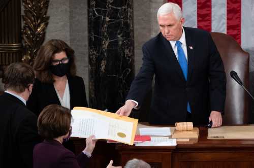 US Vice President Mike Pence hands the electoral certificate from the state of Arizona to US Senator Amy Klobuchar, Democrat of Minnesota, as he presides over a joint session of Congress to count the electoral votes for President at the US Capitol in Washington, DC, January 6, 2021. (Photo by Pool/Sipa USA)No Use UK. No Use Germany.
