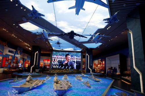 Models of military equipment and a giant screen displaying Chinese President Xi Jinping are seen at an exhibition at the Military Museum of the Chinese People's Revolution in Beijing, China October 8, 2022. REUTERS/Florence Lo
