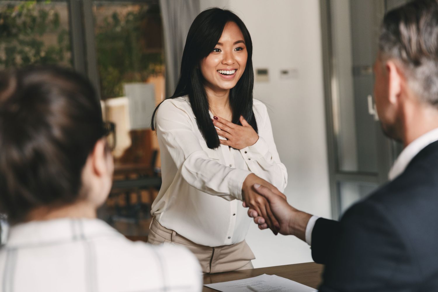 A woman shakes hands in a job interview