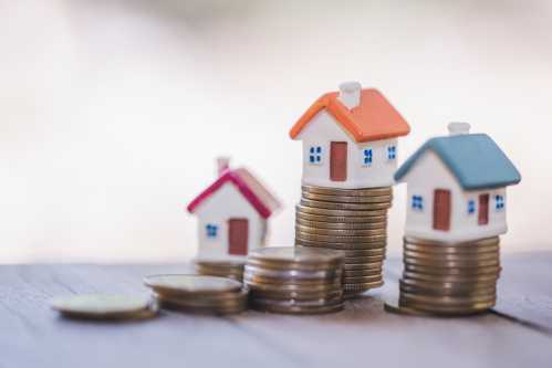 Small houses on stacks of coins