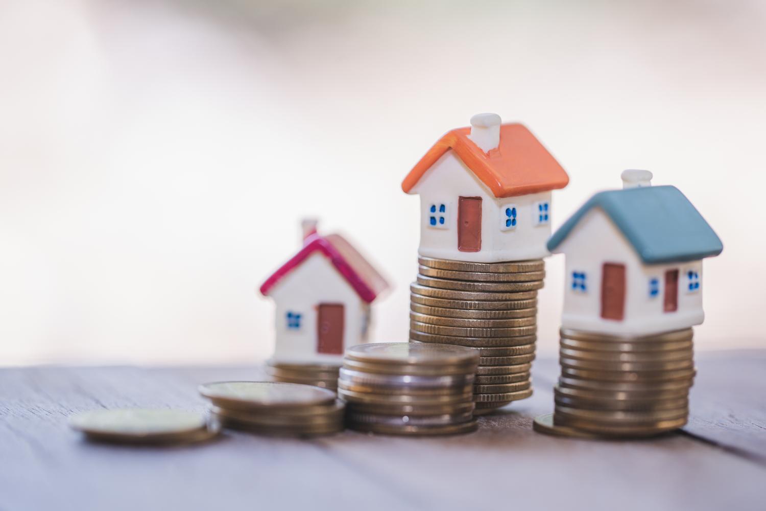 Small houses on stacks of coins