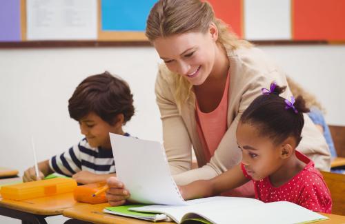 A teacher works with her students to learn math.