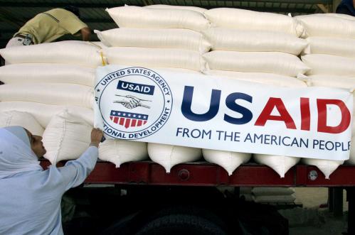 U.S. embassy staff hang a banner on a truck loaded with humanitarian aid before it is sent to Lebanon from Amman, Jordan August 31, 2006. The United States, through the Agency for International Developments (USAID), donated 700 metric tons of wheat to the World Food Program for immediate release and transport to Lebanon, according to the U.S. embassy in Amman. REUTERS/Muhammad Hamed  (JORDAN)
