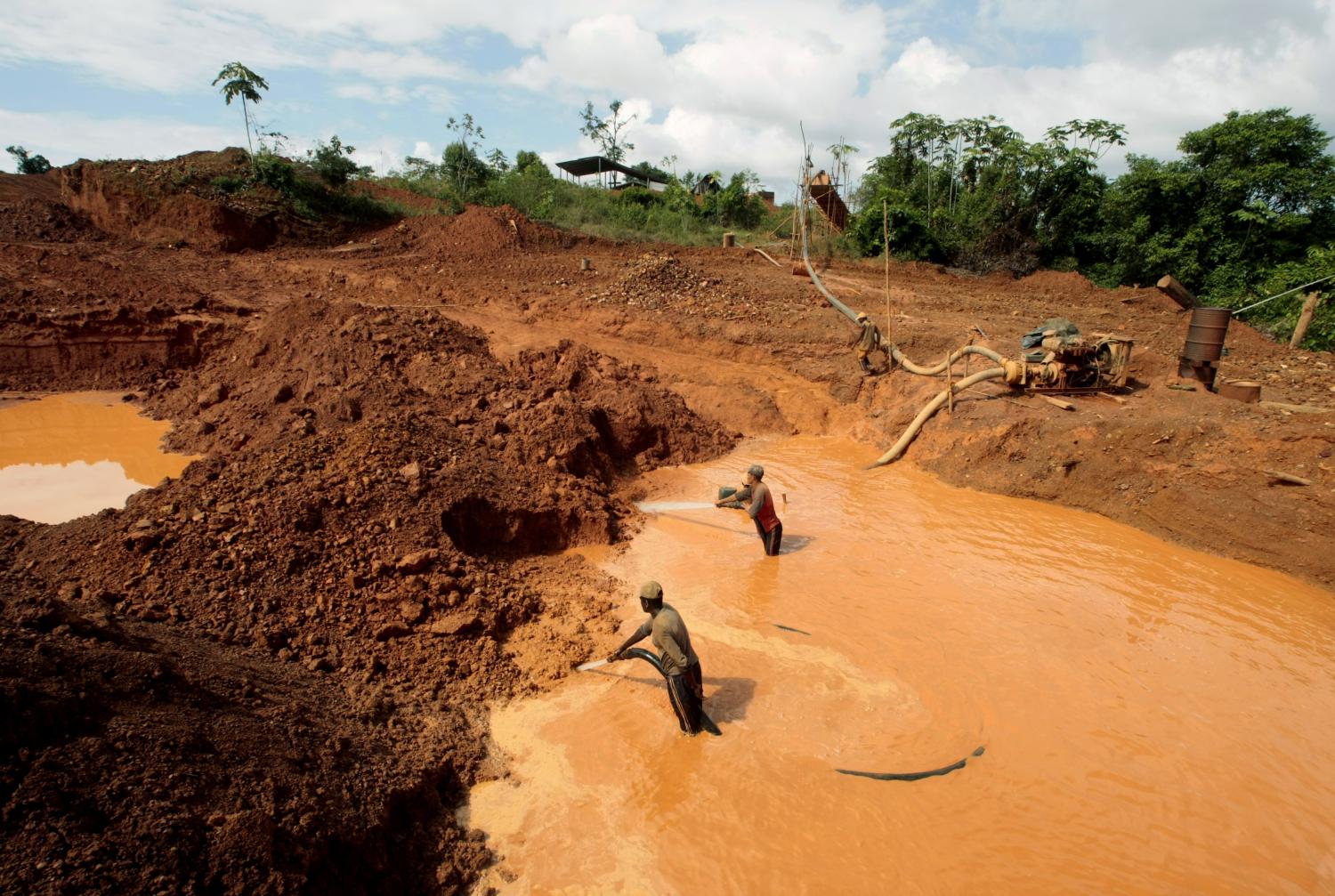 Miners use water jet to hose down the earth as they hunts for gold near at the Village Las Cristinas in southern Bolivar State January 30, 2009. Four centuries after the lure of Venezuelan gold brought ruin to English explorer Sir Walter Raleigh, the riches at one giant mine some say is cursed still haunt treasure hunters from across the globe.Located south of the Orinoco river and near a town bearing the name of the mythical golden city of El Dorado, the Las Cristinas deposit captivates miners and prospectors even though no ore has been legally dug there in two decades.Studies show it may be Latin America's top gold deposit. To match feature VENEZUELA-GOLD/  REUTERS/Henry Romero(VENEZUELA-GOLD/FEATURE ENVIRONMENT BUSINESS)