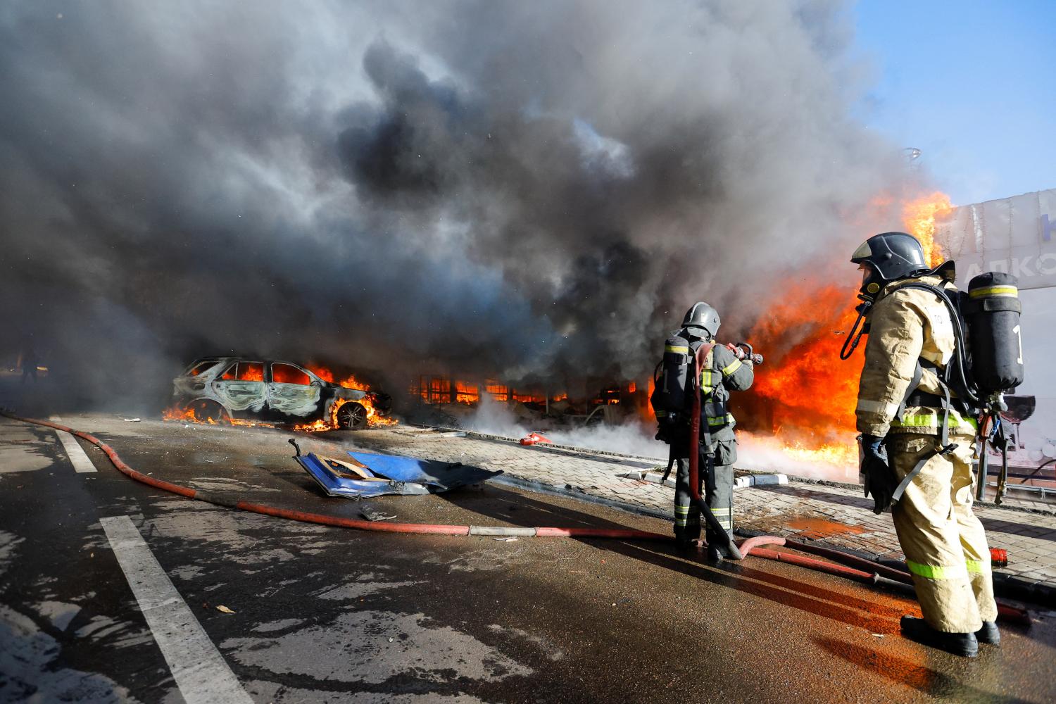 A firefighter works to extinguish fire at market stalls hit by shelling in the course of Russia-Ukraine conflict in Donetsk, Russian-controlled Ukraine, December 6, 2022. REUTERS/Alexander Ermochenko