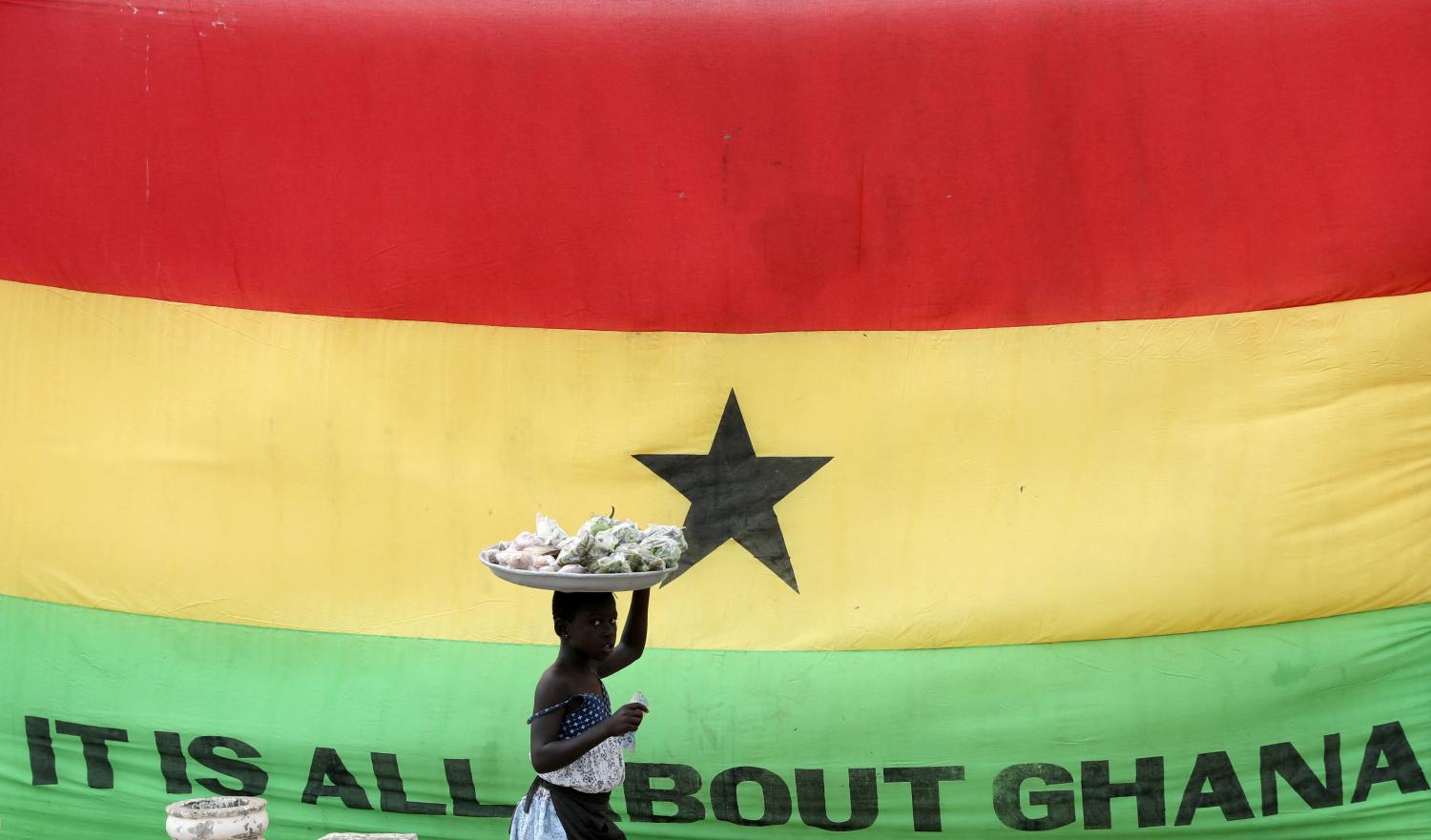 FILE PHOTO: A girl walks past a flag of Ghana outside the Cape Coast Castle, in Ghana, July 28, 2019. REUTERS/Siphiwe Sibeko/File Photo