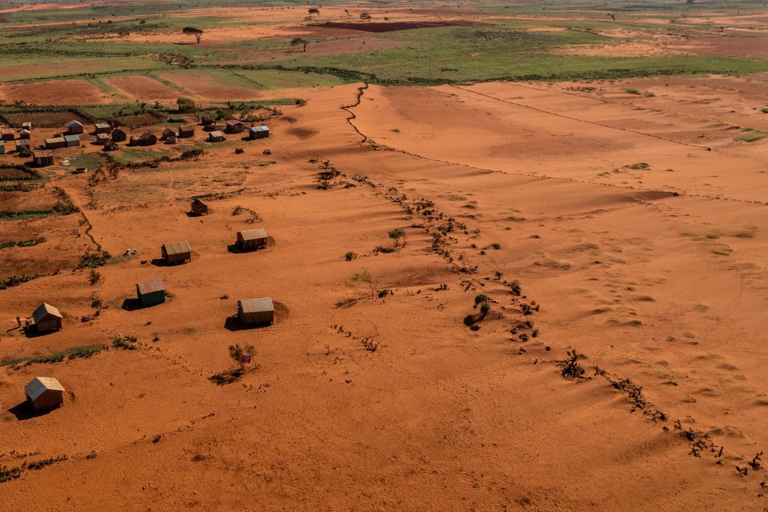 Sand begins to surround houses close to the town of Ambovombe, Androy region, Madagascar, February 15, 2022. Madagascar has always known extreme weather events, but scientists say these will likely increase as human-induced climate change pushes temperatures higher. Four years of drought, along with deforestation caused by people burning or cutting down trees to make charcoal or to open up land for farming, have transformed the area into a dust bowl.        REUTERS/Alkis Konstantinidis/File Photo        TPX IMAGES OF THE DAY        SEARCH "GLOBAL POY" FOR THIS STORY. SEARCH "REUTERS POY" FOR ALL BEST OF 2022 PACKAGES.