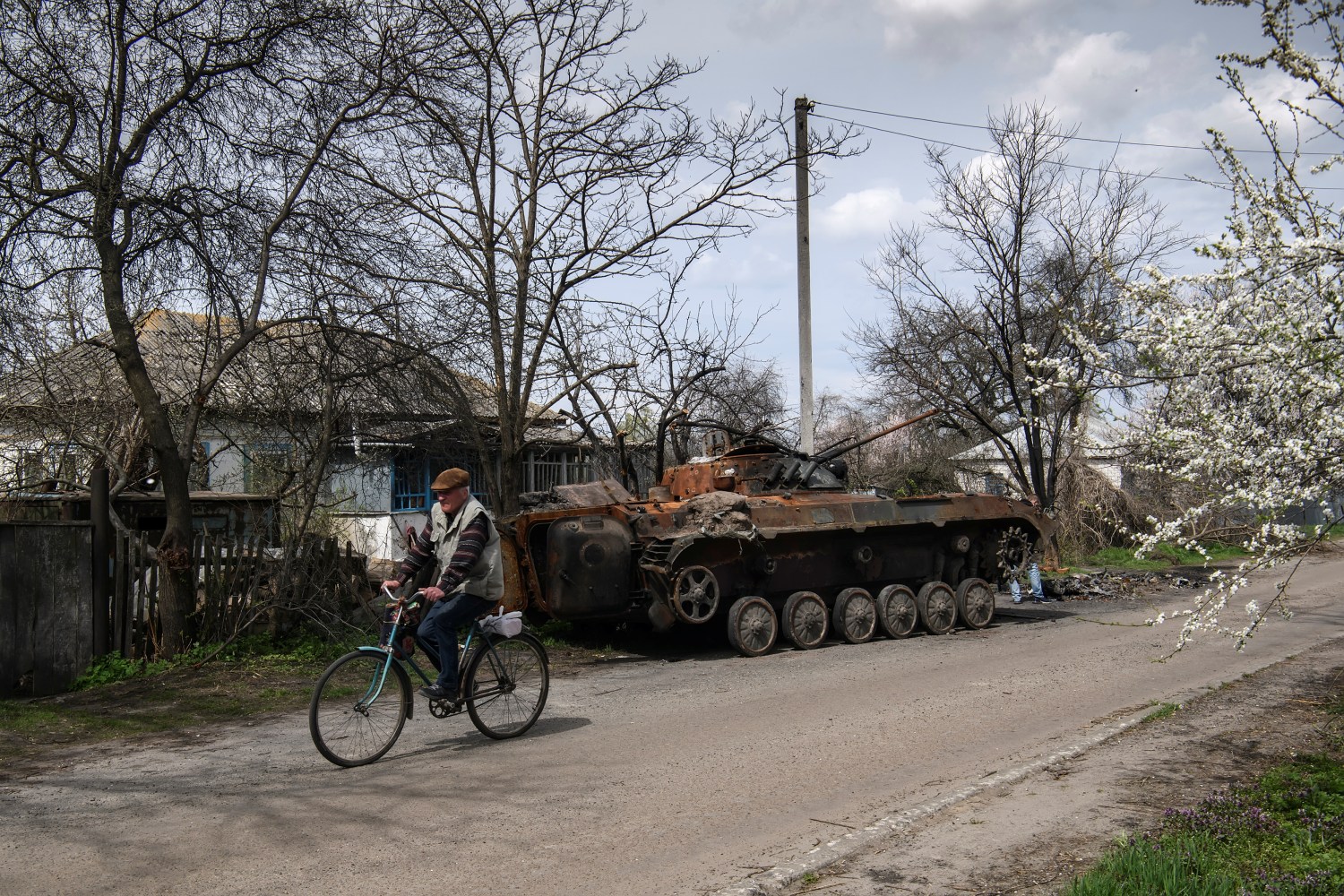 A man rides a bicycle past the debris of Russian military machinery destroyed during Russia's invasion of Ukraine, in the village of Rusaniv, Kyiv region, Ukraine April 25, 2022. REUTERS/Vladyslav Musiienko
