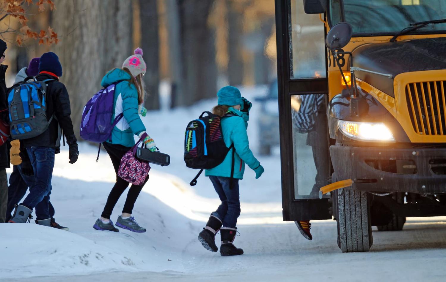 Students board their school bus in a sub-zero temperature in Minneapolis, January 8, 2014. A deadly blast of arctic air shattered decades-old temperature records as it enveloped the eastern United States on Tuesday, snarling air, road and rail travel, driving energy prices higher and overwhelming shelters for homeless people. According to AccuWeather.com, the extreme cold won't last much longer. The frigid air and "polar vortex" that affected about 240 million people in the United States and southern Canada will depart during the second half of this week, and a far-reaching January thaw will begin, according to AccuWeather.com. REUTERS/Eric Miller (UNITED STATES - Tags: ENVIRONMENT EDUCATION)
