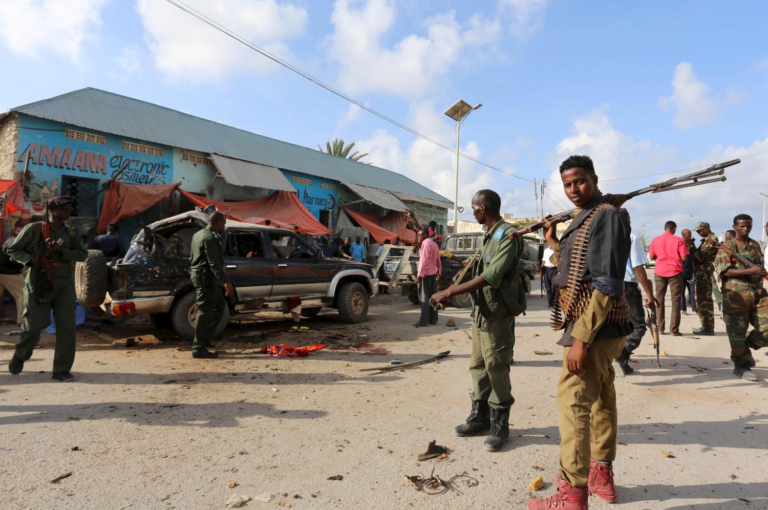 Somali policemen gather near the wreckage of a car at the scene of an explosion following an attack in Somalia's capital Mogadishu, March 9, 2016. Islamist group al Shabaab said it fought off an attack on one of its bases in southern Somalia early on Wednesday that was launched by foreign commandos who flew in on two helicopters, leaving one al Shabaab fighter dead in the gun battle. REUTERS/Feisal Omar