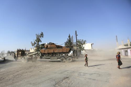 Free Syrian Army fighters walk past a Turkish tank mounted on a transporter in the northern Syrian rebel-held town of al-Rai, in Aleppo Governorate, Syria, October 5, 2016. REUTERS/Khalil Ashawi