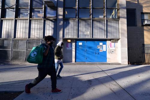 Two people walk past the closed side entrance of The International High School for Health Sciences Q236 as elementary schools are set to reopen on Dec.7, New York, NY, December 6, 2020. New York City Mayor Bill de Blasio announced that public pre-K and elementary schools can return to in-person learning on Dec. 7., while middle and high schools remain closed; Schools were closed on Nov. 18 when the city surpassed the 3% infection rate threshold set by the Mayor de Blasio. (Photo by Anthony Behar/Sipa USA)