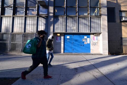 Two people walk past the closed side entrance of The International High School for Health Sciences Q236 as elementary schools are set to reopen on Dec.7, New York, NY, December 6, 2020. New York City Mayor Bill de Blasio announced that public pre-K and elementary schools can return to in-person learning on Dec. 7., while middle and high schools remain closed; Schools were closed on Nov. 18 when the city surpassed the 3% infection rate threshold set by the Mayor de Blasio. (Photo by Anthony Behar/Sipa USA)No Use UK. No Use Germany.