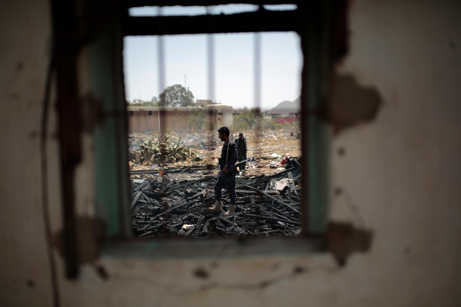 A Yemeni policeman inspects a site that was damaged by an air strike allegedly carried out by the Saudi-led coalition, a day after the Houthis rebels targeted Saudi Arabia's oil facilities with rocket attacks.