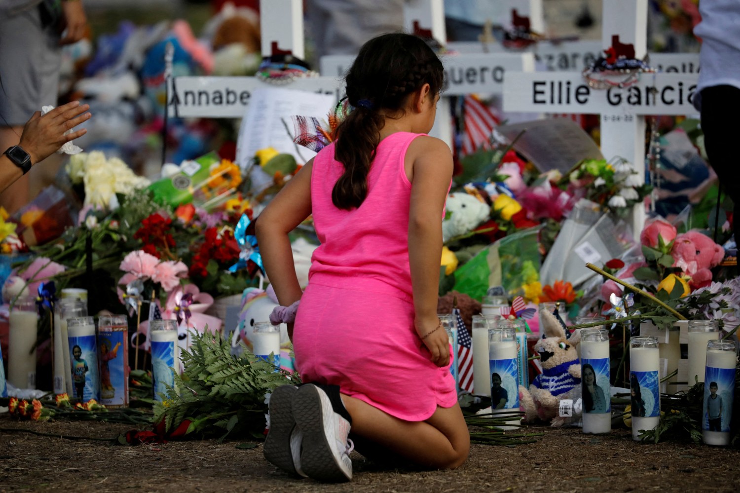 A girl pays respects at the memorial at Robb Elementary school, where a gunman killed 19 children and two adults, in Uvalde, Texas, U.S. May 28, 2022. REUTERS/Marco Bello      TPX IMAGES OF THE DAY