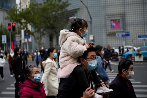 People wearing face masks cross a street, as coronavirus disease (COVID-19) outbreaks continue in Shanghai, China, December 8, 2022. REUTERS/Aly Song