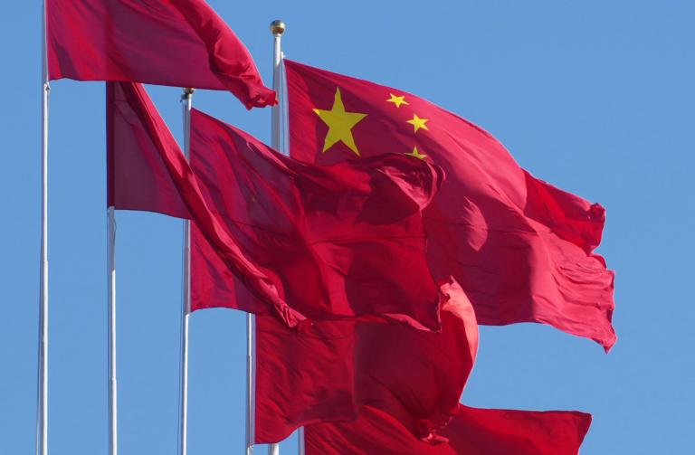 Chinese national flags and the red flags are streamed in the wind on the rooftop at Great Hall of the People in Beijing, China on January 2, 2023. Lots of people visit the Tiananmen Square which contains the Monument to the People's Heroes, the Great Hall of the People, the National Museum of China, and the Mausoleum of Mao Zedong.( The Yomiuri Shimbun )