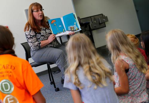 Reference librarian Marlayna Christensen reads to children Dr. Seuss new book "What Pet Should I Get?" at the University of California San Diego's Geisel Library in San Diego, California July 28, 2015. The story is based on materials found two years ago in a box at the La Jolla home of Audrey Geisel, the widow of Theodor "Dr. Seuss" Geisel, who wrote the children's classics "The Cat in the Hat" and "Green Eggs and Ham". REUTERS/Mike Blake