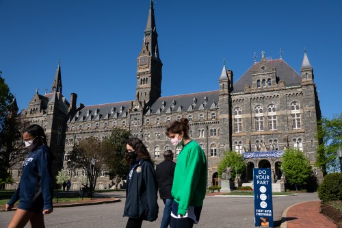 Students and pedestrians walk near Healy Hall at Georgetown University, in Washington, D.C., on Monday, April 26, 2021, amid the coronavirus pandemic. As the 2020-2021 school year comes to a close, colleges and universities across the country are making announcements about vaccine requirements for the upcoming academic year  Georgetown University recently announced it will require vaccines for all graduate and undergraduate students returning to campus in the Fall. (Graeme Sloan/Sipa USA)No Use Germany.