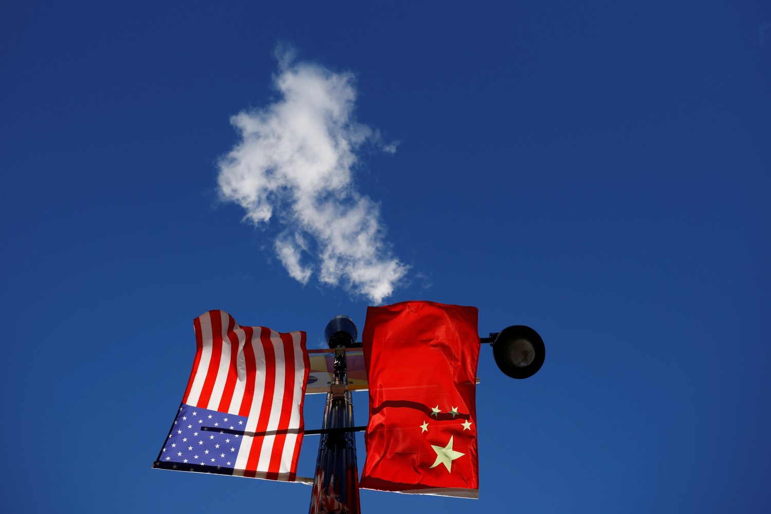 The flags of the United States and China fly from a lamppost in the Chinatown neighborhood of Boston, Massachusetts, U.S., November 1, 2021.   REUTERS/Brian Snyder