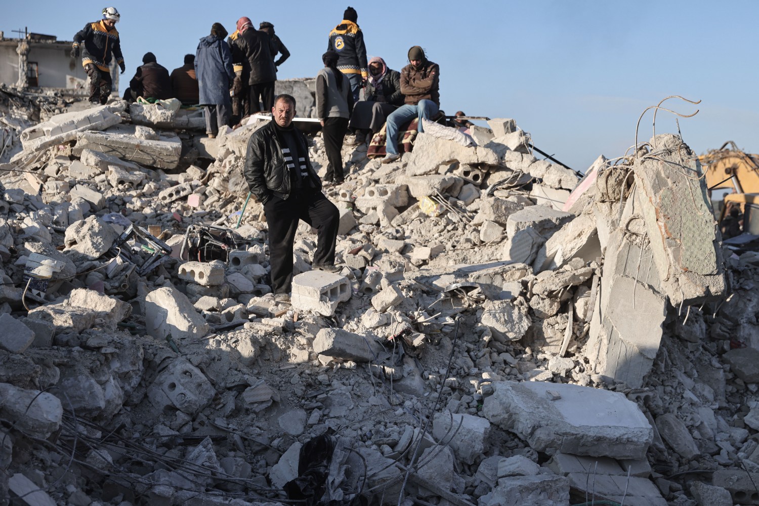 Civilians and White Helmets members inspect a building that collapsed in the city of Harem following the devastating earthquake that struck the Turkish-Syrian border and left more than 5000 people dead.