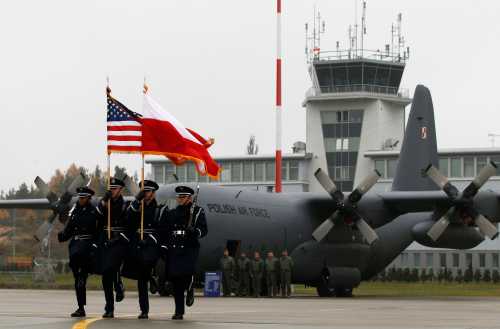 U.S. soldiers carry flags of both Poland and the United States during the opening ceremony of the first United States Air Force (USAF) aviation detachment in Poland, at an air force base in Lask near Lodz, central Poland, November 9, 2012. The United States launched its first permanent military presence on Polish soil on Friday, an air force detachment to service warplanes, in a move long sought by its NATO ally Warsaw. REUTERS/Kacper Pempel (POLAND  - Tags: POLITICS MILITARY)