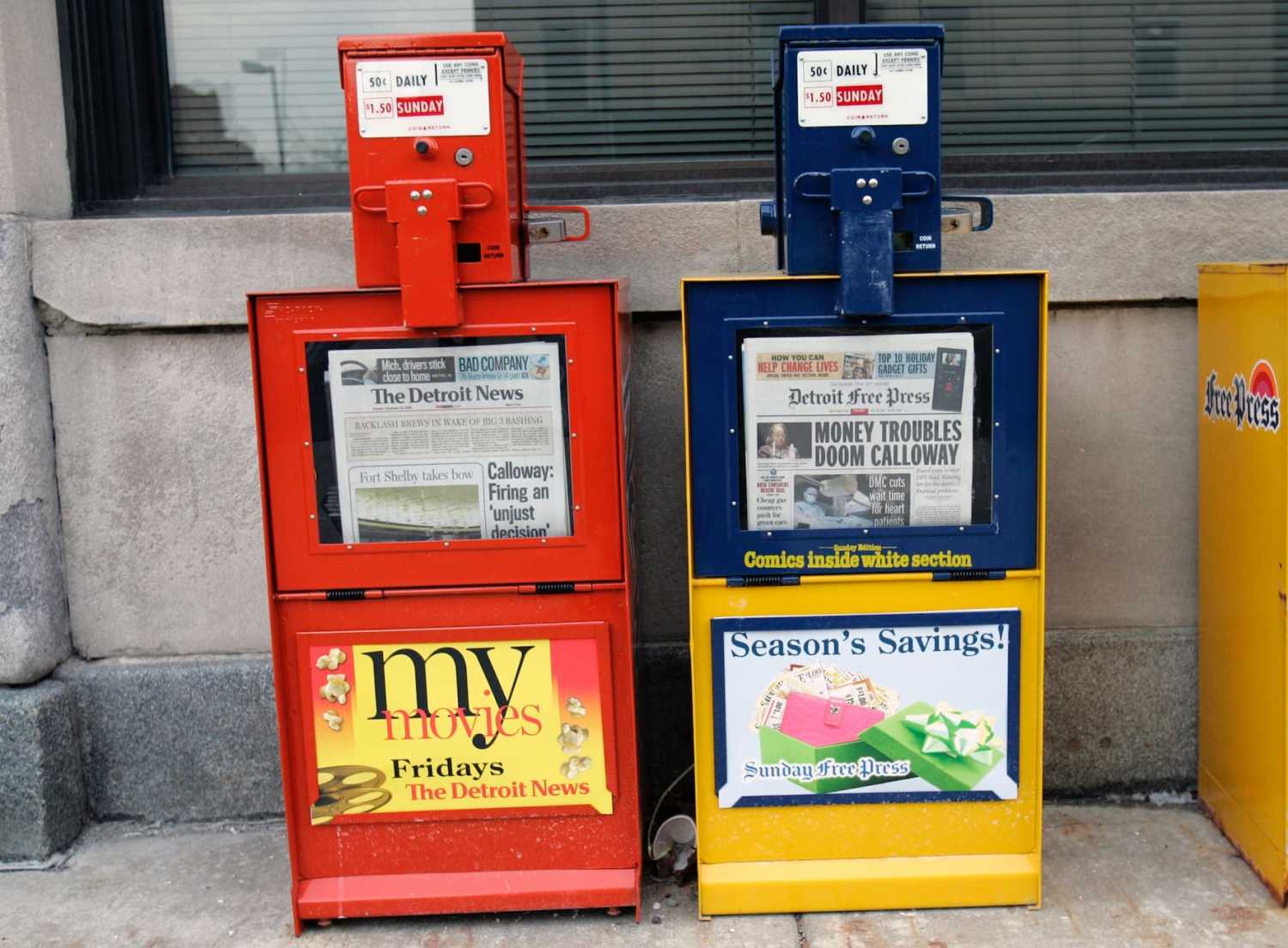 Detroit News and Detroit Free Press paper boxes sit in front of the papers building in Detroit, Michigan December 16, 2008. The Newspapers Partnership announced a plan to reduce home-delivery of the papers to three days a week and a push for their on-line editions. REUTERS/Rebecca Cook (UNITED STATES) - GM1E4CH0A2K01