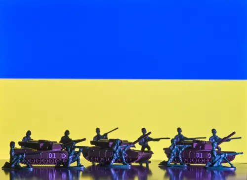 Illustration of a mini replica of tanks and soldiers, seen in front of the Ukrainian flag in Krakow, Poland. (Photo by Artur Widak/NurPhoto)