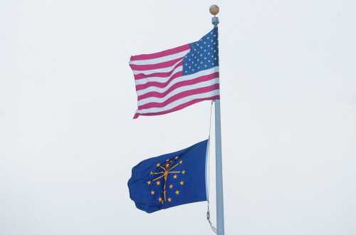 An American and State of Indiana flag fly Friday, Dec. 23, 2022, during a frigidly cold day in Central Indiana.