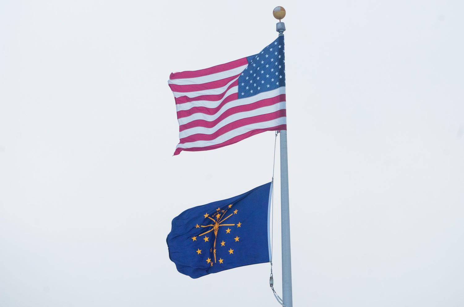 An American and State of Indiana flag fly Friday, Dec. 23, 2022, during a frigidly cold day in Central Indiana.